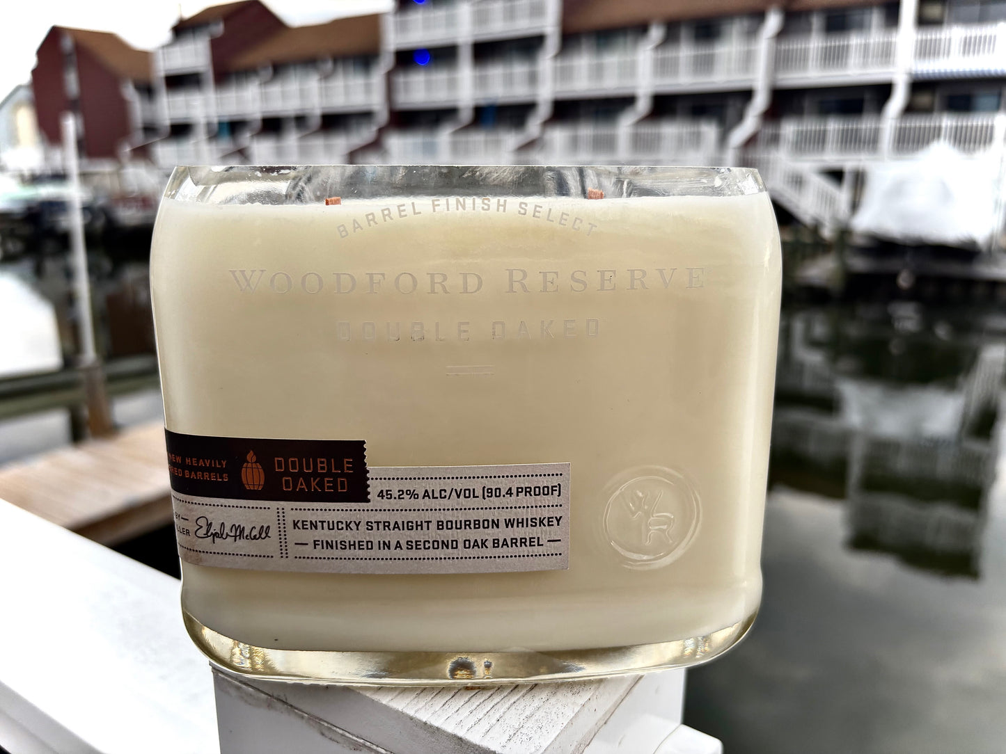Woodford Reserve bourbon bottle with a blurred background of a building and water.